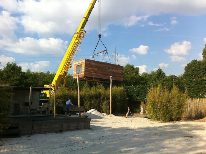 Gele hijskraan aan het werk bij de aanleg van een groenproject