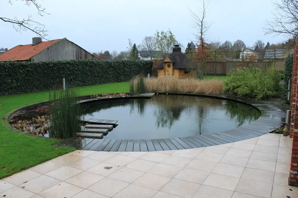 Zwemvijver met natuurstenen terras en beplanting langs de rand