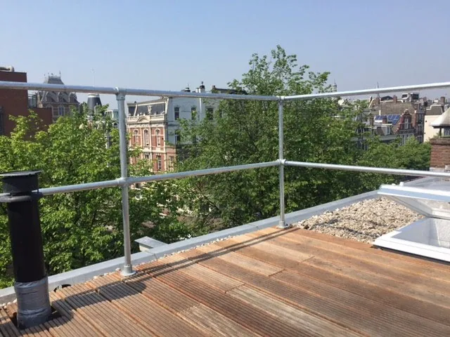 Dakterras met stalen balustrade en beplanting, met uitzicht over de stad